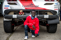 Samba, un enfant sénégalais sauvé par Mécénat Chirurgie Cardiaque, avec le Peugeot 2008 DKR15+ de Romain Dumas et François Borsotto
