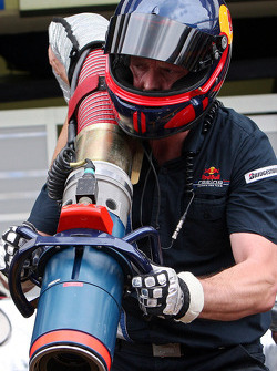 Un membre d'équipage Red Bull Racing avec l'injecteur de carburant pendant un entraînement aux stands
